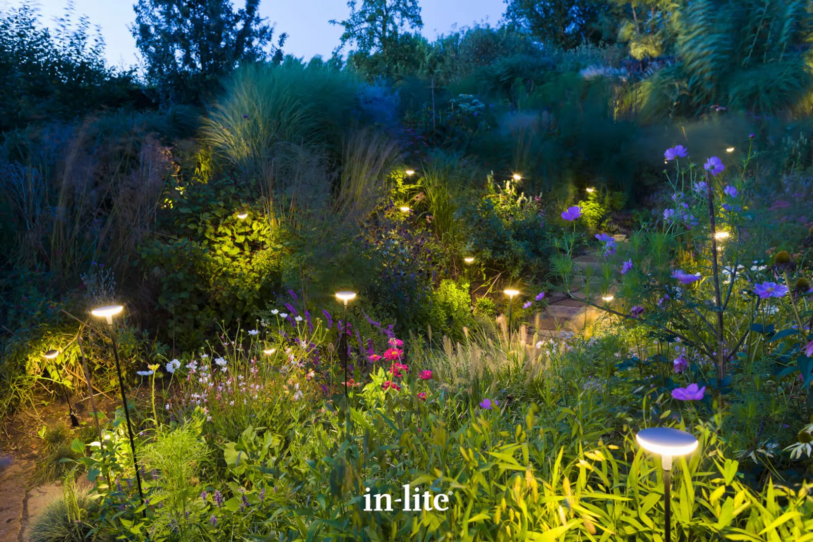 in-lite Gartenbeleuchtung in einem Staudenbeet in der Dämmerung