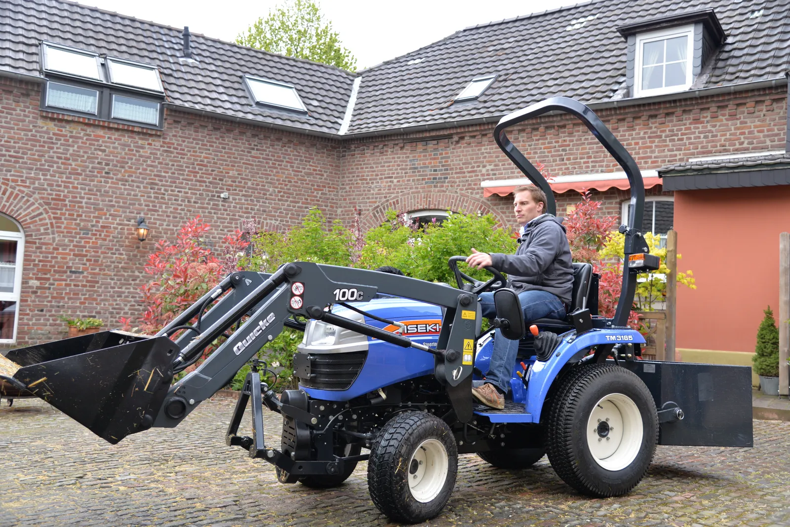 ISEKI Kompakttraktor mit Frontlader in einer Hofeinfahrt